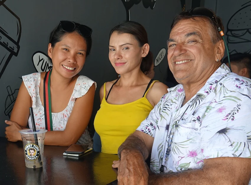 Three customers smiling and enjoying an afternoon chat with boba milk tea.
